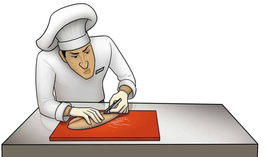 A chef removes a physical hazard, bone, from fish.